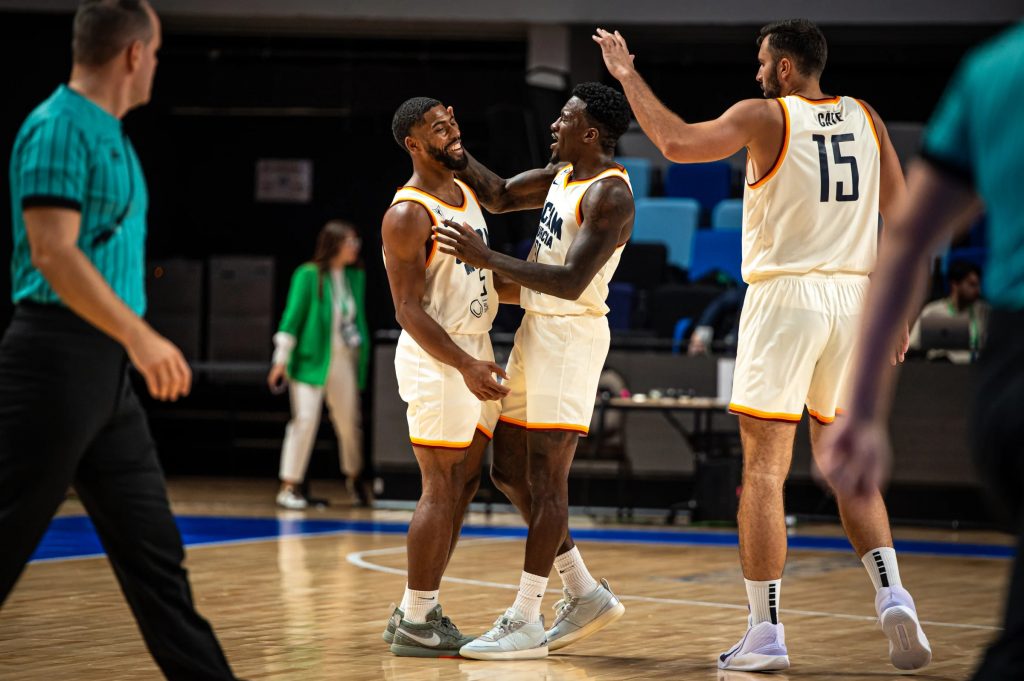 DeJulius, Ennis y Çate celebran en un tiempo muerto.